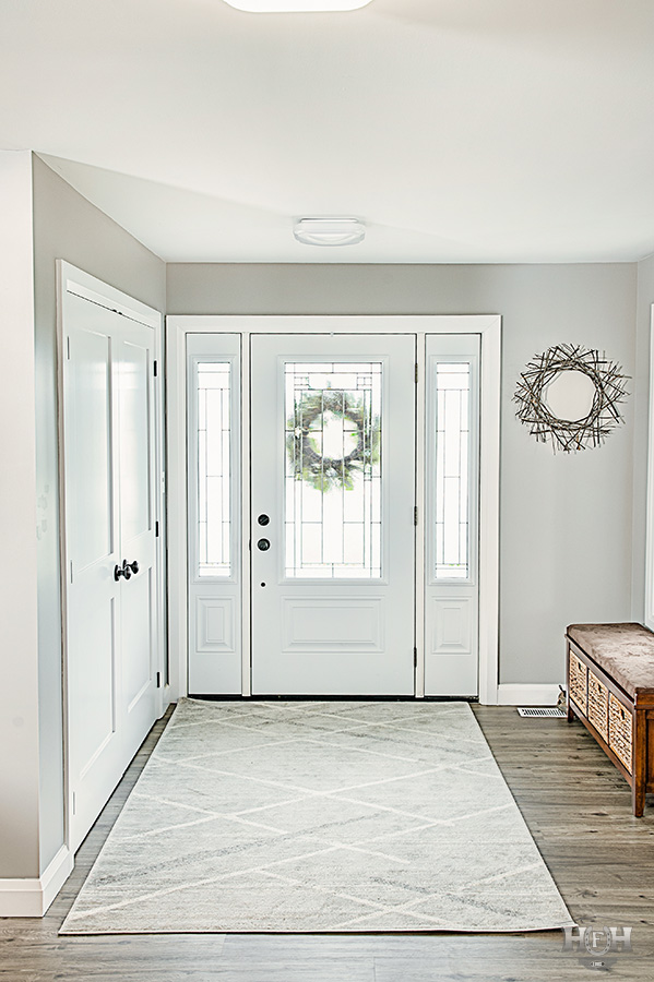 Front hall entrance white rug and white door